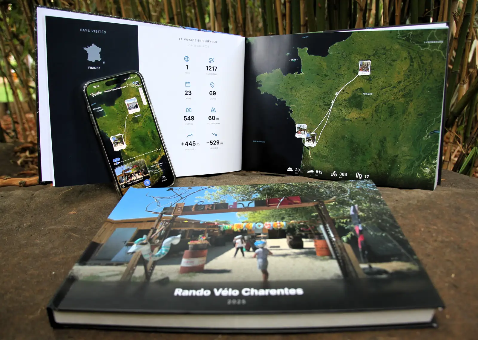 Le livre ouvert sur la carte du voyage et ses chiffres, à côté du téléphone affichant le même voyage