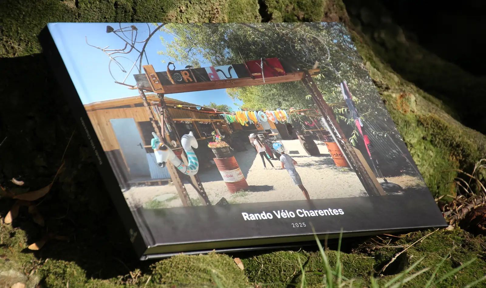 Le livre TalesMap refermé, posé sur la mousse au pied d’un arbre